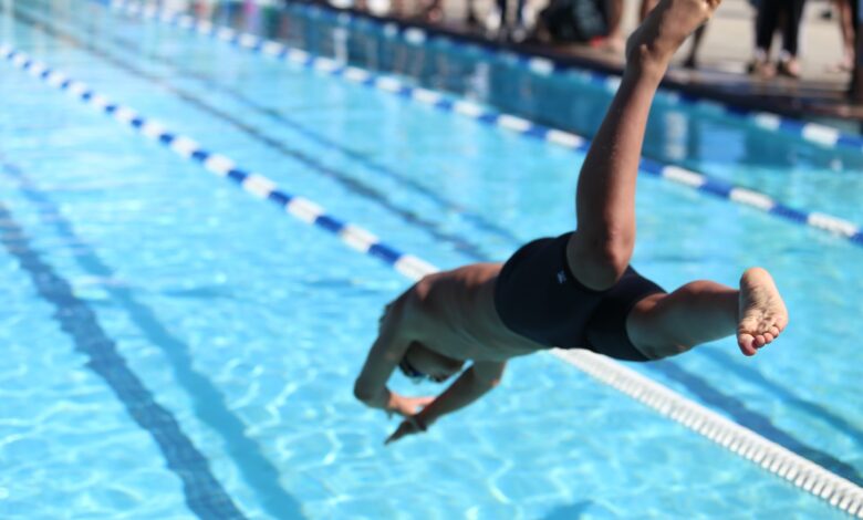 Swimmer jumping into water
